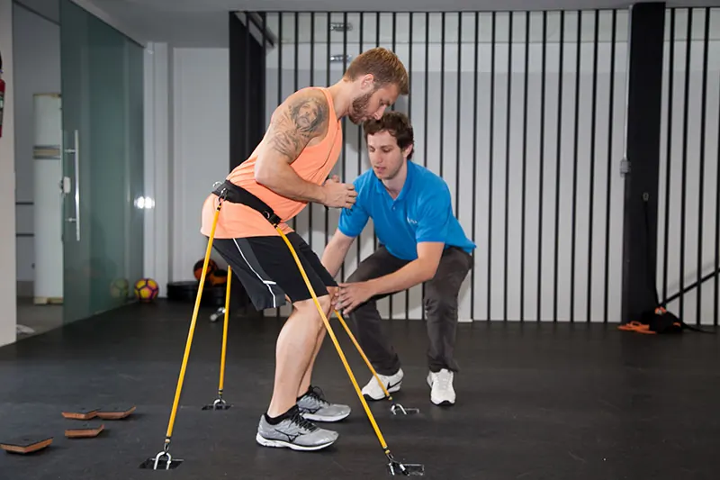 Atleta realizando exercício de fortalecimento com acompanhamento de fisioterapeuta esportivo
